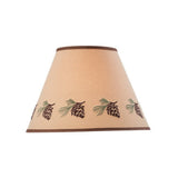 A conical lampshade with a warm beige background and a printed border of pinecones and pine needles, set against a plain white background.