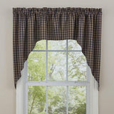 Bridgeton navy and tan gingham check curtain swag hanging on a white window frame, with a green yard visible outside.