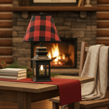 Black lantern lamp with red-check shade in a rustic cabin