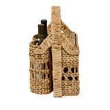 Side angle view of Cinthia Hyacinth Wine Basket Caddy with two wine bottles in woven slots, open lattice weave detail and arched handle, natural tan finish