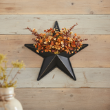 Faceted metal star wall hanging on wood wall with fall florals
