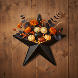 Faceted metal star wall hanging with Halloween florals, mini pumpkins, and candy corn