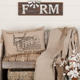 Farmstead Charcoal Plow Harvest Throw Pillow 22x14 styled on a wood bench in a farmhouse living room with shiplap wall and wood accents