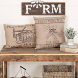 Farmstead Charcoal Plow Harvest Throw Pillow styled on a rustic wood entryway bench alongside a coordinating Indian Corn Feed pillow under a Farm sign on shiplap wall