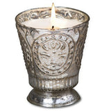 Fleur de Lys Silver Tumbler Hand-Poured Soy Scented Candle with an embossed floral medallion design, containing a white candle that is lit with a visible flame, set against a plain white background.