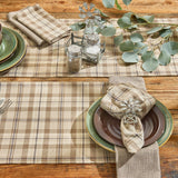 Tinderbox Brown Plaid Cloth Napkins styled with matching plaid table runner and placemats on a farmhouse wood dining table, with green stoneware plates, windmill napkin rings, and eucalyptus greenery