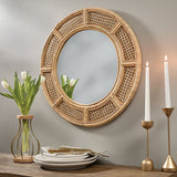 Rattan Round Mirror on a wall with decorative items including tulips, plates, and candles.