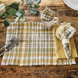 Sage & Mustard Plaid Cloth Napkin in white, sage green, putty brown and mustard yellow is wrapped around a white ribbed napkin ring, placed on a Sage & Mustard chndi placemat visible on a rustic wooden table with a white mug that contains the Sage & Mustard Dishcloth.
