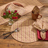 Simmons plaid quilted placemats, table runner and napkins styled on a farmhouse dining table with heart napkin rings and a vase with red flowers and babies breath.
