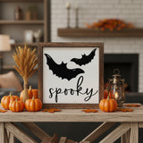 Spooky Halloween wood sign in rustic wood box frame displayed on a farmhouse table with mini pumpkins, wheat stems, and a lantern