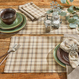 Tinderbox Brown Plaid Placemats on a rustic wood dining table with green stoneware plates, plaid napkin with windmill napkin ring, and eucalyptus greenery — farmhouse cotton table setting