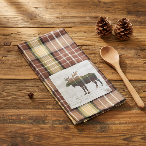 Friar Brown Plaid Moose Dishtowel on a wood table with wood spoon and pinecones
