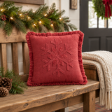 Red Snowflake Stone Washed Fringed Pillow on a Christmas-themed wooden bench