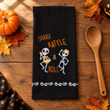 Square lifestyle image of the towel on a wood table with a wooden spoon and Halloween accents